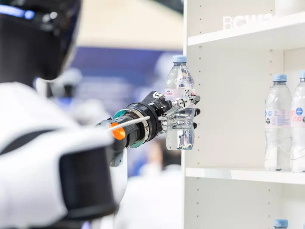 Un robot humanoide coge una bebida de una estantería y la coloca sobre el mostrador. La demostración en Bosch Connected World 2026 muestra las capacidades clave de los sistemas humanoides en un proceso concreto de manipulación.